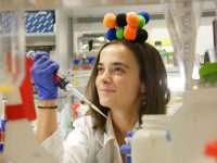 Carmen Majano en el laboratorio con un modelo de la chaperona CCT en la cabeza